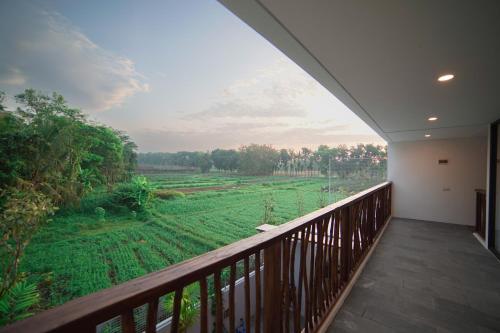 a balcony with a view of a green field at Ubu Villa Amarta in Yogyakarta in Ngaglik