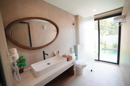 a bathroom with a sink and a mirror on the wall at Ubu Villa Amarta in Yogyakarta in Ngaglik