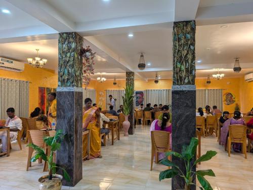 a group of people sitting at tables in a restaurant at Dip Holidays in Shānti Niketan