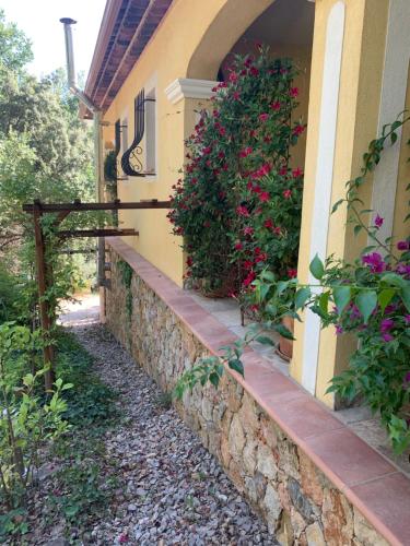 une maison avec un mur en pierre et des fleurs dans l'établissement Aux IRIS, à Flayosc