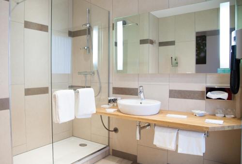 a bathroom with a sink and a shower at Mercure Poitiers Centre in Poitiers