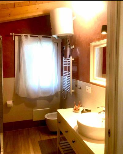 a bathroom with a sink and a toilet and a window at Mini Alloggi Il Vigneto del Borgo in Due Carrare