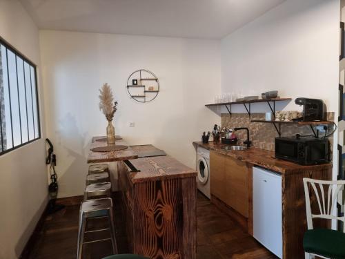 - une cuisine avec un comptoir en bois et une cuisinière dans l'établissement Prestigieuse Résidence ST MARIE - Appt 2 Chambres - N 20, à Bellac