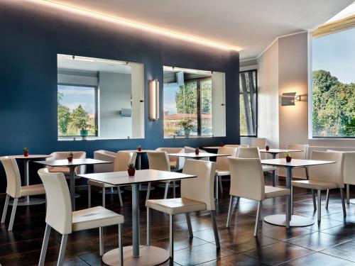 a dining room with white tables and chairs at Holiday Inn Express Milan-Malpensa Airport by IHG in Case Nuove