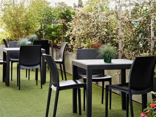 a row of tables and chairs in a garden at Holiday Inn Express Milan-Malpensa Airport by IHG in Case Nuove