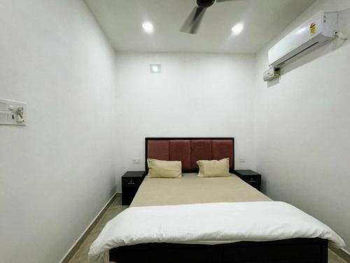 a bedroom with a large bed with white walls at Divine Kashi Near Shree Kashi Vishwanath Temple in Varanasi