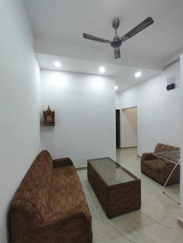 a living room with two couches and a ceiling fan at Divine Kashi Near Shree Kashi Vishwanath Temple in Varanasi
