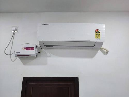 a printer is hanging on a white wall at Divine Kashi Near Shree Kashi Vishwanath Temple in Varanasi