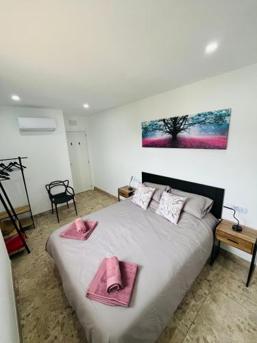 a bedroom with a bed with pink towels on it at RenBeck lets 2 in Urcal