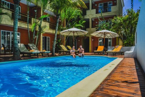 two people sitting in the pool at a hotel at La Margarita in Pointe aux Piments
