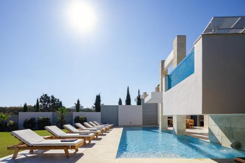 una piscina con sedie a sdraio accanto a un edificio di Villa Aroma a Chania
