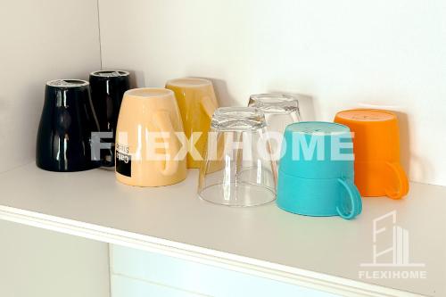a row of different colored glasses sitting on a shelf at FREE Streaming Services-Designed Studio Home at Cybersquare, Cyberjaya by Flexihome-MY in Cyberjaya