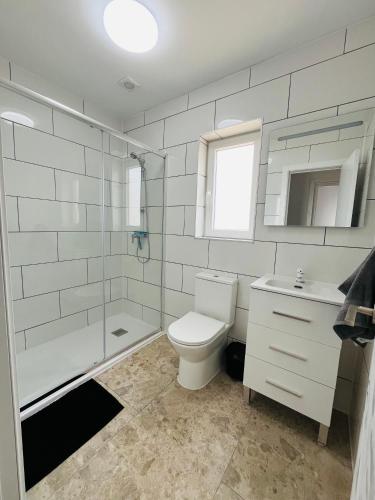 a bathroom with a toilet and a sink and a shower at RenBeck lets 2 in Urcal