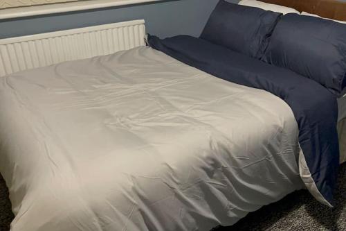 1 cama con sábanas azules y blancas y almohadas azules en House of Peace & Rest, en Mánchester