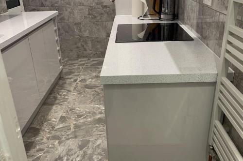 Una cocina con encimera blanca y suelo de mármol. en House of Peace & Rest, en Mánchester