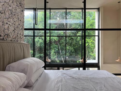 a bedroom with two beds and a large window at Villa Escondida - Riviera Maya in Puerto Morelos