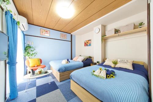 a bedroom with two beds and a chair at Belmont 303 3min to Station Easy Access Ueno Asakusa Skytree Sleeps 4 in Tokyo