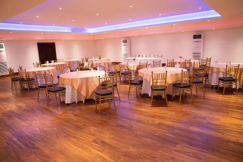 a banquet hall with white tables and chairs at Good wood Airport Hotel in Katunayake