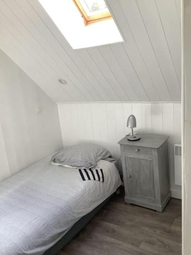 une chambre avec un lit et une table avec une lampe dans l'établissement Longère terre mer, à Plélo