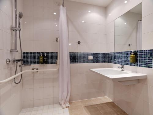 a white bathroom with a sink and a shower at Holiday Inn Express Milan-Malpensa Airport by IHG in Case Nuove