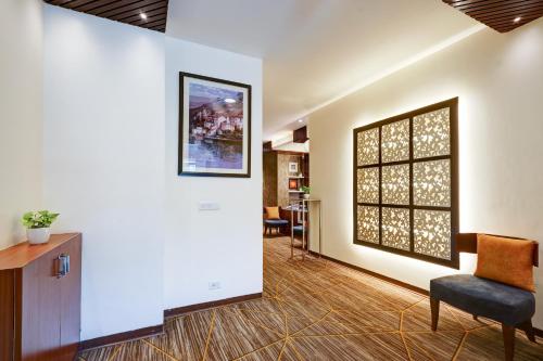 a waiting room with a chair and a picture on the wall at Hotel 91 Golf Course Road in Gurgaon