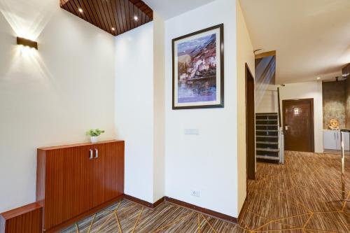 a hallway with white walls and a painting on the wall at Hotel 91 Golf Course Road in Gurgaon