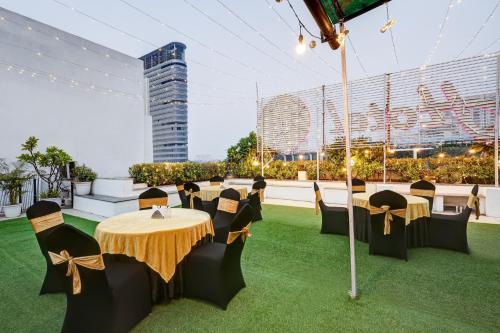 a restaurant with tables and chairs on a roof at Hotel 91 Golf Course Road in Gurgaon