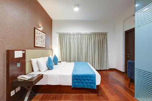 a hotel room with a bed with a blue blanket at Hotel 91 Golf Course Road in Gurgaon