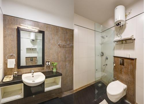 a bathroom with a sink and a toilet and a mirror at Hotel 91 Golf Course Road in Gurgaon