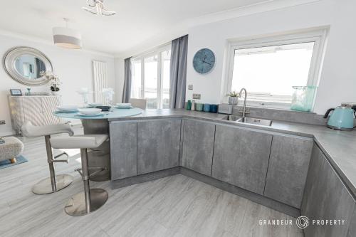a kitchen with a sink and a table in it at Seaview Retreat by Grandeur Property in Southbourne