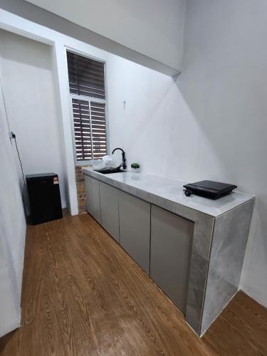 a kitchen with a counter with a laptop on it at Tamu 1980 Studio in Kampong Molek