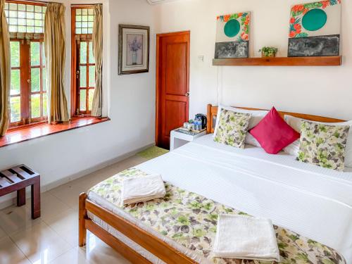 a bedroom with a large bed and windows at Airport Green Olive Villa in Katunayaka