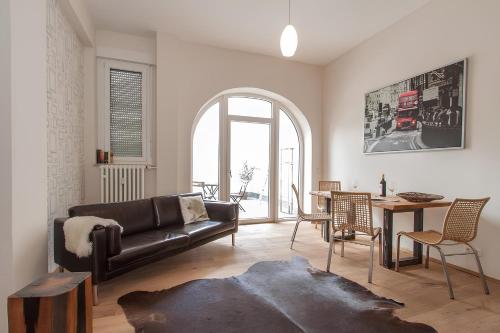 a living room with a black couch and a table at Wohnen am Kulturspeicher mit eigenem Parkplatz in Würzburg