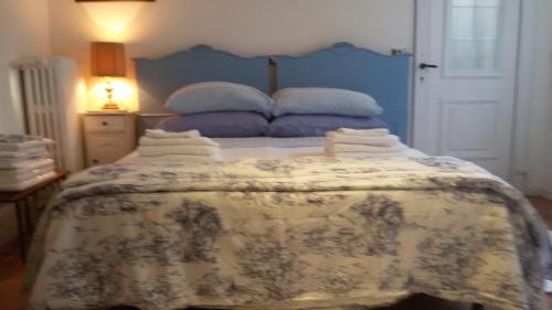 a bedroom with a bed with a blue and white blanket at Villa Fiorita in Monfalcone