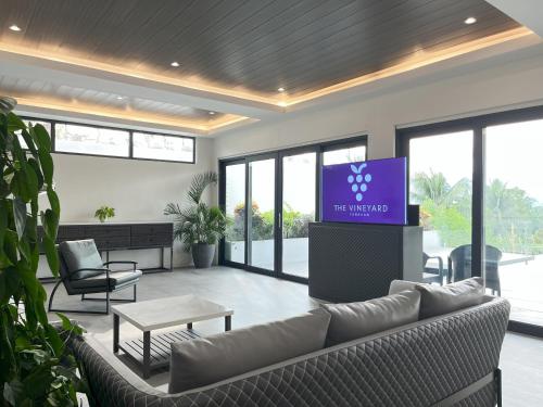 a living room with a couch and a tv at The Vineyard at Tanauan in Tanauan