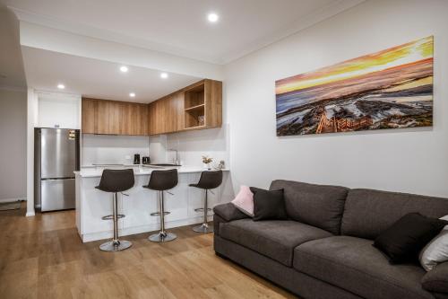 a living room with a couch and a kitchen at Seabreeze Esperance in Esperance