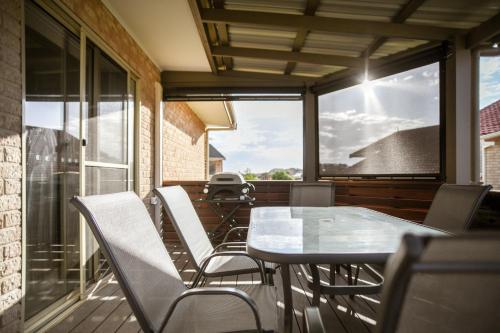 a balcony with a table and chairs and a large window at Seabreeze Esperance in Esperance