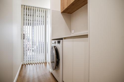 a laundry room with a washing machine and a window at Seabreeze Esperance in Esperance