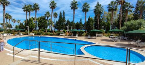 a pool at a resort with palm trees at F3-Costa Marina III World, Jovial - ServHouse in El Borseral