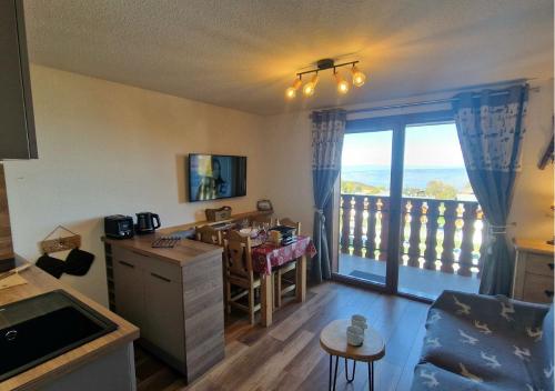 d'une cuisine et d'une salle à manger avec vue sur un balcon. dans l'établissement Le Flocon de Thollon, à Thollon-les-Mémises