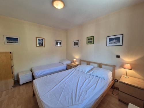 - une chambre avec 2 lits, une table de nuit et 2 lampes dans l'établissement LES 5 LACS J2 - Bel appartement centre-ville, à Bourg-Saint-Maurice