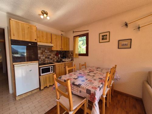 une cuisine et une salle à manger avec une table et des chaises dans l'établissement LES 5 LACS J2 - Bel appartement centre-ville, à Bourg-Saint-Maurice
