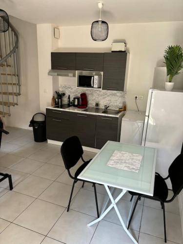 une cuisine avec une table, des chaises et un réfrigérateur dans l'établissement Location bail mobilité etudiant cadre, à Bordeaux