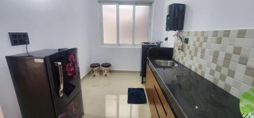 a small kitchen with a refrigerator and a sink at SD Zanita Heights Sea Facing Serviced Apartments in Vasco Da Gama