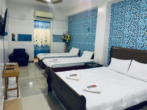 a hotel room with two beds and a chair at SEACOAST HOTEL AND RESORTS in Mactan
