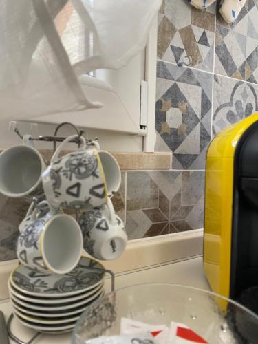 a kitchen counter with a stack of plates and cups at MareSol in Marsala