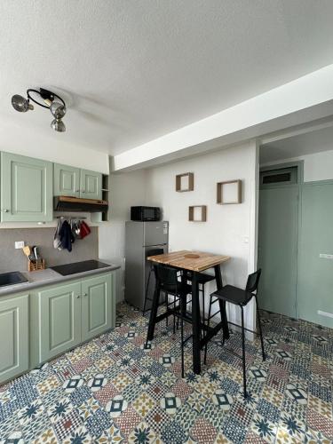 - une cuisine avec une table, une table et des chaises dans l'établissement La Petite Fuxéenne, à Foix