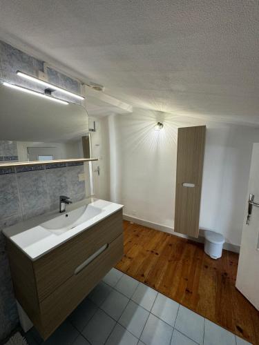 une salle de bain avec un lavabo et un miroir dans l'établissement La Petite Fuxéenne, à Foix