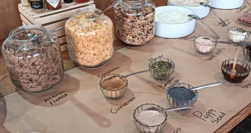 a table with four jars filled with different types of food at ANEW Hotel & Convention Centre OR Tambo Johannesburg in Benoni