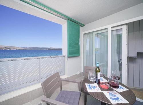 a dining room with a table and chairs with a view of the ocean at Villa Krapljunka in Krapanj